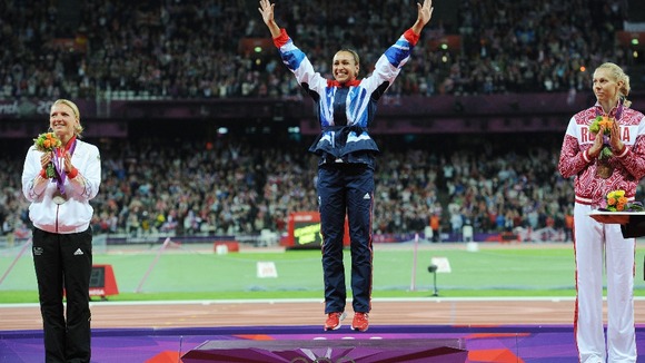 Ennis celebrates on the podium, watched by silver medal winner Lilli Schwarzkopf (left) and bronze medallist Tatyana Chernova (right).