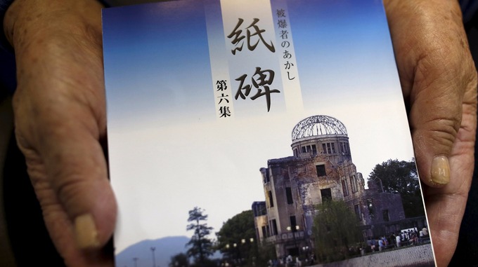 Makiko Kato, an 85-year-old atomic bomb survivor, holds a book recording survivors' experience of being witness to the horrors of atomic bombs for future generations 