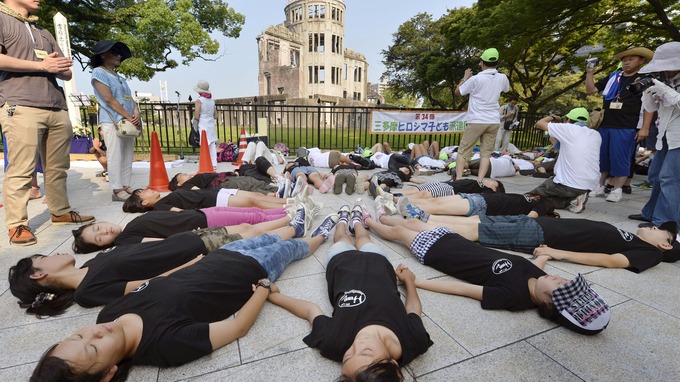 Children perform a die-in in front of the Atomic Bomb Dome at Peace Memorial Park in Hiroshima