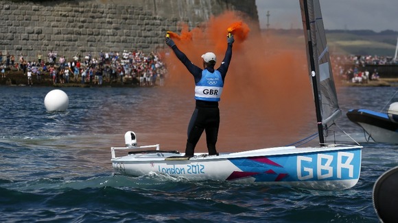 Ben Ainslie holds flares as he celebrates winning the men's finn class one person dinghy (heavyweight) medal race sailing competition.