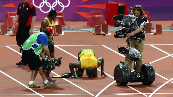 Bolt kisses the 100m track in celebration.