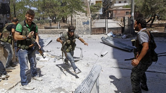 A Free Syrian Army fighter runs for cover during clashes with Syrian Army soldiers in the Salah al- Din neighbourhood of central Aleppo.