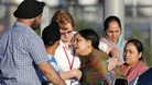A distraught women is helped to a car outside of the Sikh temple in Oak Creek, Wisconsin.