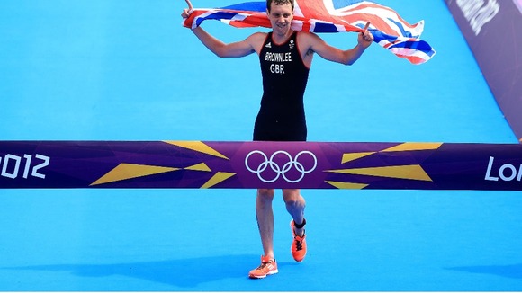 Alistair crosses the line with a flag he was given by a spectator on the home straight.