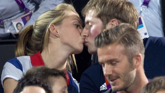 Gold medal-winning British cyclists Laura Trott and Jason Kenny kiss during the women's beach volleyball final