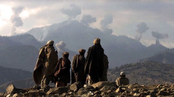 Anti-Taliban Afghan fighters watch explosions from US bombings in the Tora Bora mountains