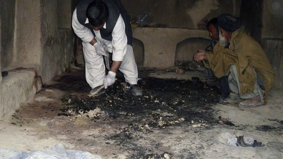 Afghan men investigate at the site of an shooting incident in Kandahar province
