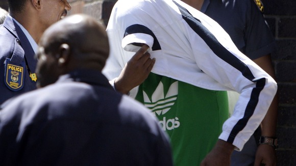 Xolile Mngeni seen at an earlier court appearance covering his head