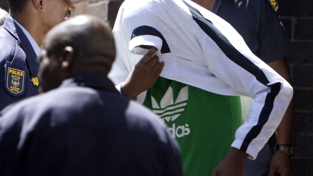 Xolile Mngeni seen at an earlier court appearance covering his head