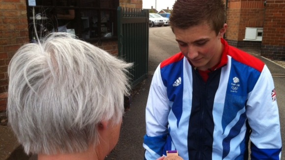 Sam Oldham showing his medal to a fan