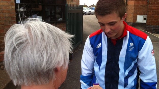 Sam Oldham showing his medal to a fan