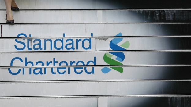 A woman walks down the stairs of the Standard Chartered headquarters in Hong Kong October 13, 2010.