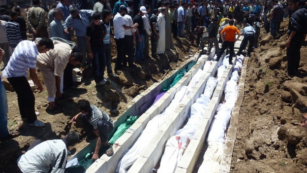 People gather at a mass burial for the victims purportedly killed during an artillery barrage from Syrian forces in Houla