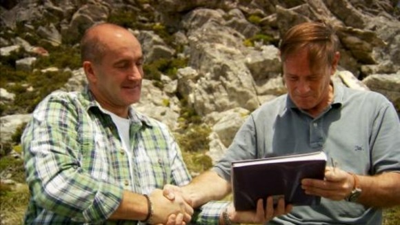 Nick Taylor gives Marcello Llambias a photo album containing the photographs he took in 1982