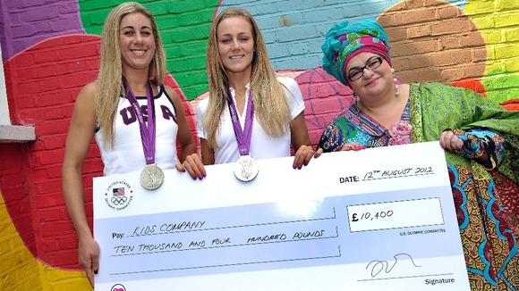 April Ross and Jen Kessy present a check to Kid's Company founder Camila Batmanghelidjh