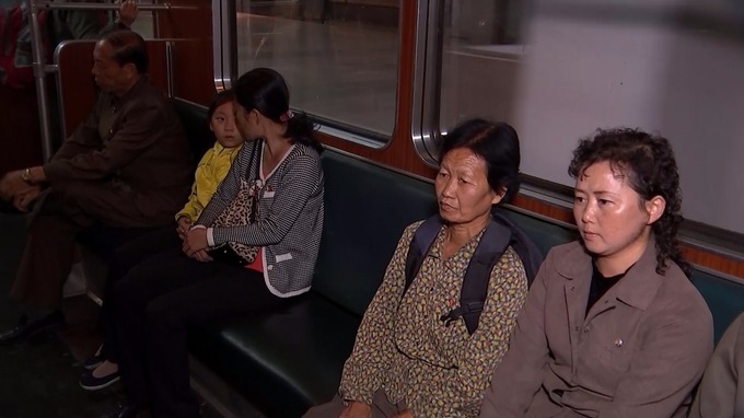 Passengers listen to patriotic music played over the metro speakers.