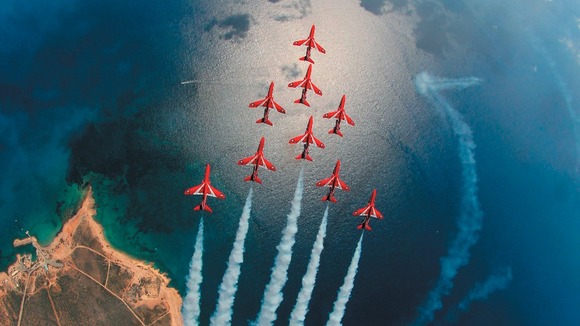 The Red Arrows fly over the sea