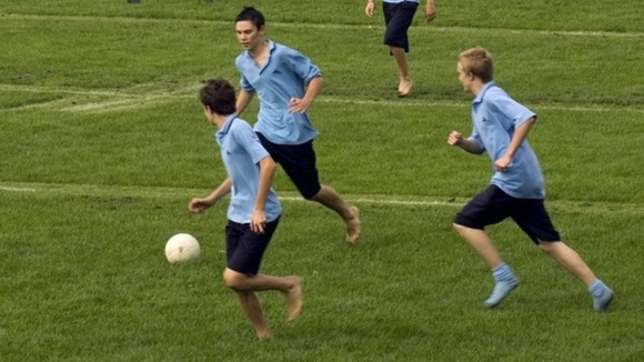 Students play football on a field