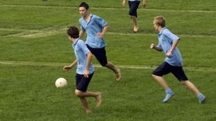 Students play football on a field