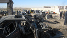 People and security forces inspect the scene of a car bomb attack in Kirkuk