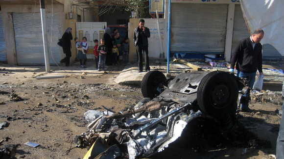 People inspect the scene of a car bomb attack in Kirkuk, Iraq
