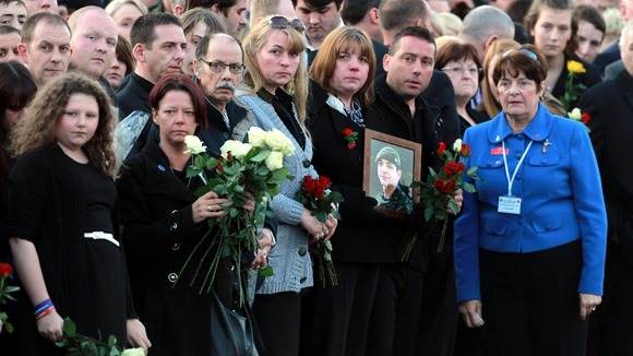 Family and friends wait for the funeral cortege