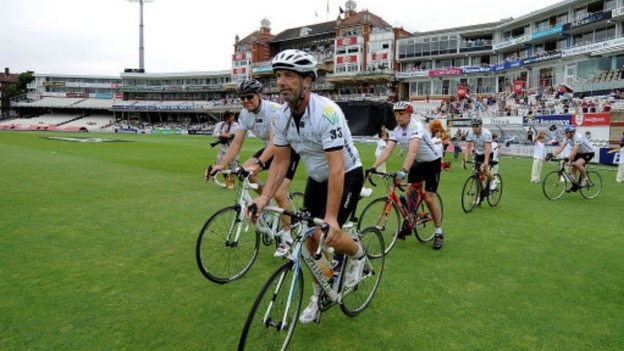 Matthew Maynard leads cyclists onto the pitch at the Oval