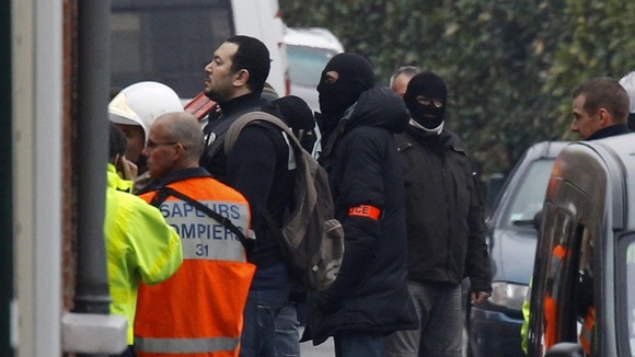 Police officers and firefighters stand near a building in Toulouse,