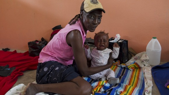 Residents of camps for displaced people of the 2010 earthquake are evacuated to a local school