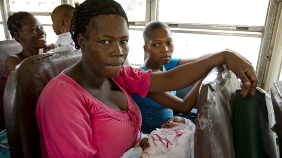 Residents of a camp for displaced people of the 2010 earthquake evacuate in the wake of arriving tropical storm Isaac, Port au Prince