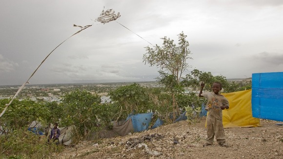 A boy flies his kite in the increasing winds as tropical Storm Issac strengthens