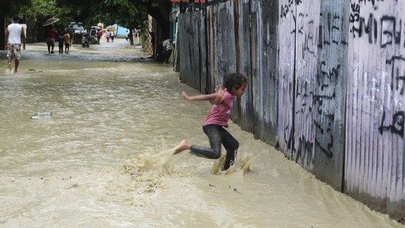 A child runs through floodwater from Tropical Storm Isaac in Vicente Noble