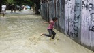 A child runs through floodwater from Tropical Storm Isaac in Vicente Noble
