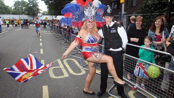 One of the dancers with a police officer takes part in the Notting Hill Carnival in west London.