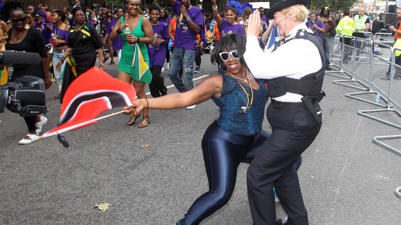Police Sergeant Siobhan Elliot dances with revellers at the Notting Hill Carnival in west London.