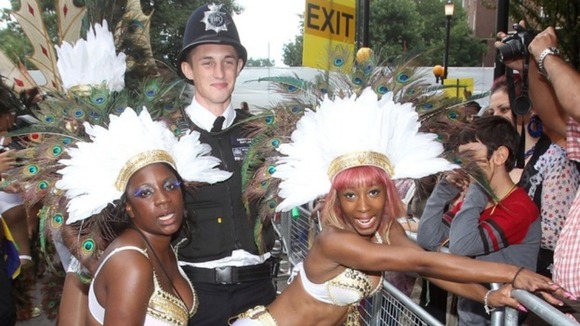 Policeman with performers during the Notting Hill Carnival, London.