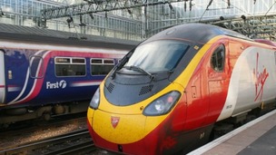A First service passes a Virgin Pendolino train in Glasgow Central Station. 