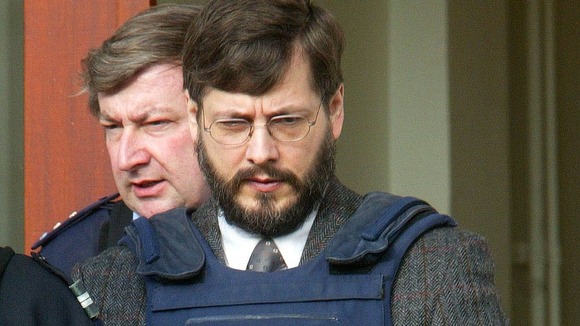 Belgian convicted child rapist Marc Dutroux leaves court escorted by police officers in 2003