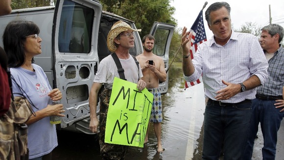 Mitt Romney talks to people on the side of the road while looking at damage from Hurricane Isaac in Jean Lafitte