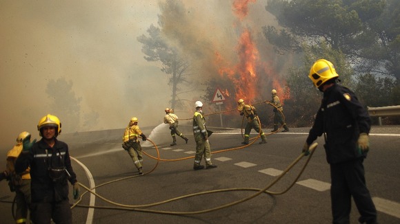 Firefighters try to extinguish fire in forest on road between Marbella and Monda in Ojen