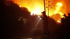 Members of the Civil Protection service look for people inside a chalet during a general evacuation at a residential area