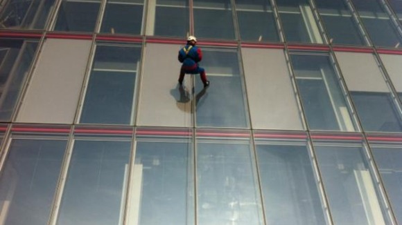 A person dressed in a Spider-Man outfit abseils down London's Shard building.
