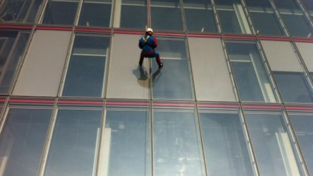 A person dressed in a Spider-Man outfit abseils down London's Shard building.