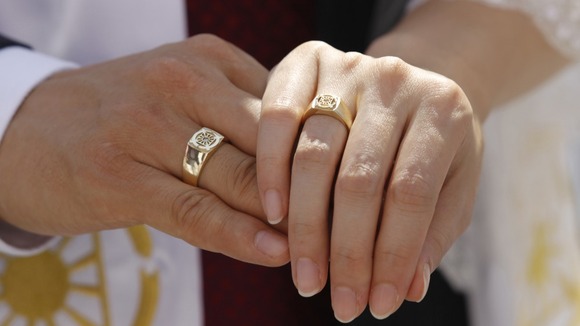 Newlyweds fold their hands at a mass wedding ceremony of the Unification Church at Sun Moon University in Asan, south of Seoul in 2010