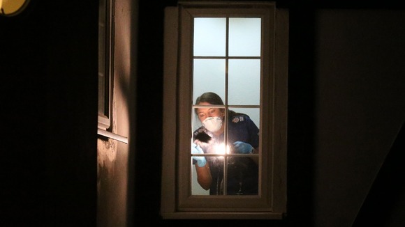 A British Scene of Crime Officer checks for prints at the al-Hilli family home