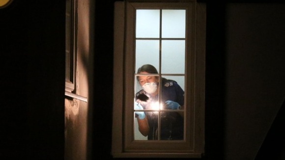 A British Scene of Crime Officer checks for prints at the al-Hilli family home