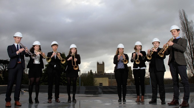 Musicians don hard hats to perform on roof