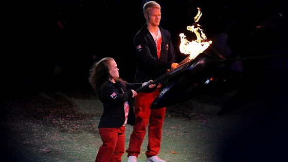 Ellie Simmonds and Jonnie Peacock light their torches from the Paralympic Flame