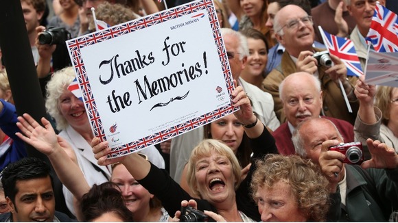 A member of the crowd holds up a sign as a parade celebrating Britain's Olympic and Paralympic sporting heroes makes its way through London.