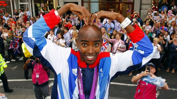 Mo Farah does the 'Mobot' as he takes part in a parade through London